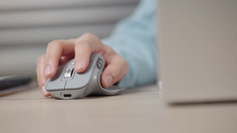 close-up hand of a businessman using wireless or bluetooth mouse. scrolling the wheel working with a pc or laptop.