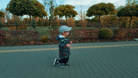 energetic joyful kid runs by the park in autumn. happy active time spending outdoors.