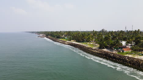 Aerial-View-Of-Breakwaters-With-Lush-Palm-Trees-In-The-Tropics-Of-Indian-Shore