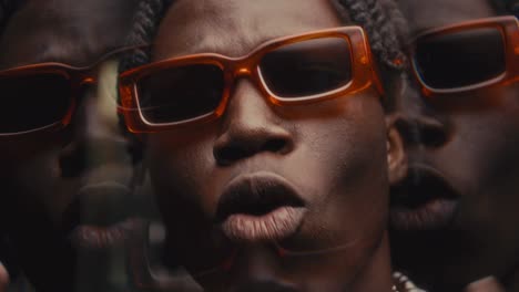 kaleidoscopic effect of black rapper in sunglasses performing hip-hop on camera