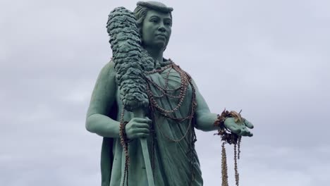 Cinematic-booming-up-shot-of-the-commemorative-Queen-Ka'ahumanu-statue-in-Hana-Beach-Park-on-the-island-of-Maui,-Hawai'i