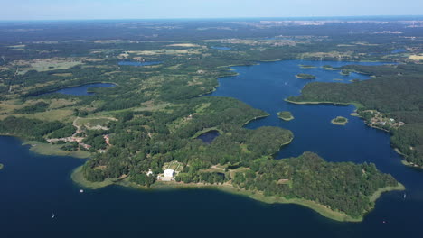 aerial: slow panning shot in very high altitude of trakai nature with trees forest and lake visible in the background