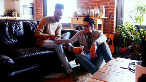 Gay-couple-using-digital-tablet-and-mobile-phone