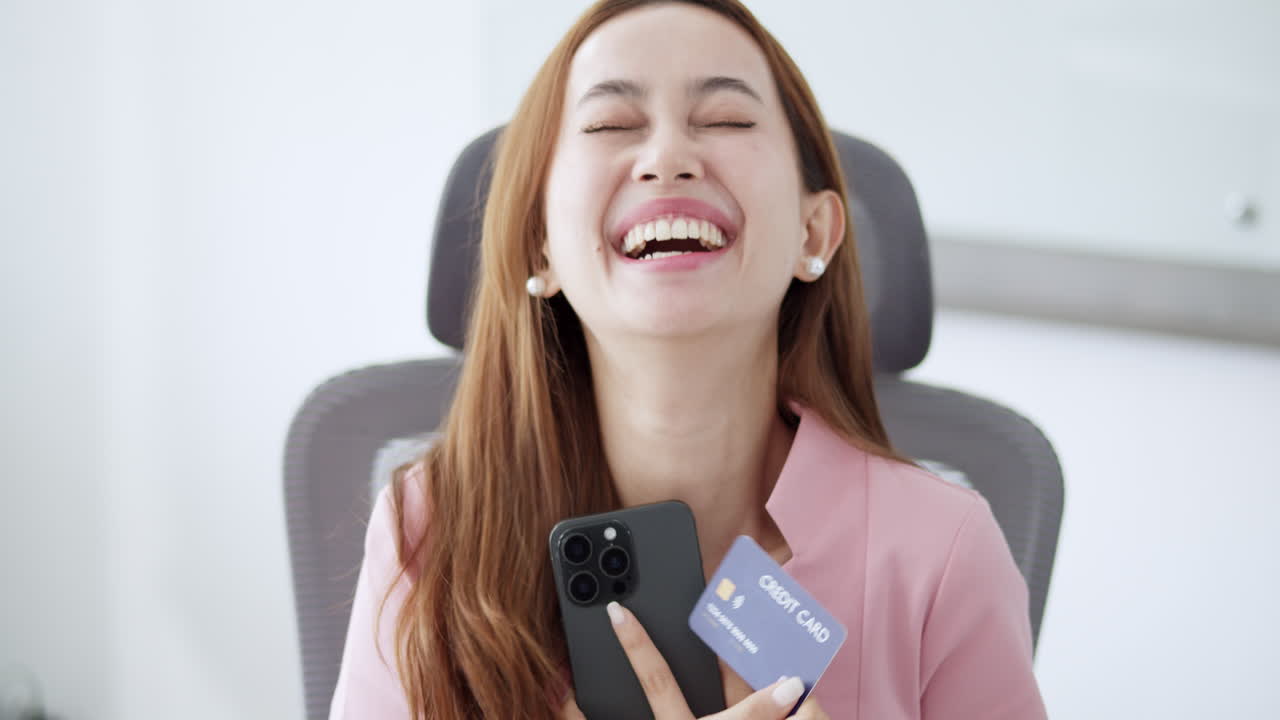 A thrilled woman celebrates her successful online purchase showcasing joy and excitement in her home office.