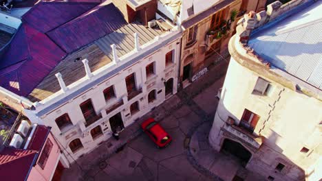 Aerial-view-establishing-on-the-cobblestone-streets-of-the-Concha-y-Toro-neighborhood-with-a-red-car-parked-Santiago-Chile