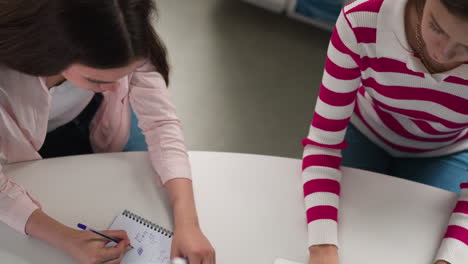 classmates do homework using different sources. students write searching data on internet and study books in public hall. education process in college