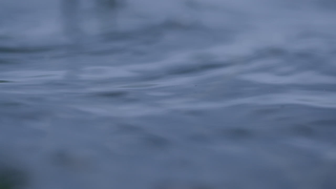 Slow mo of rain droplets splashing in a puddle during a tropical storm causing flooding