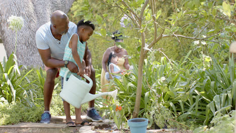 Happy-african-american-grandfather-with-grandson-working-in-garden,-in-slow-motion