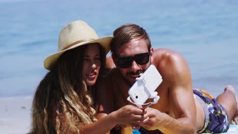 pareja tomando una selfie desde el teléfono móvil en la playa