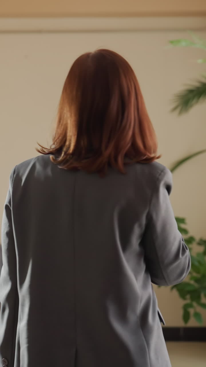 사무실에서 자동판매기에서 음료를 고르는 비즈니스 여성, 편안한 사무실 휴식, 정장을 입은 여성, 최신 자동판매기 사용, 사무실 환경, 음료 선택, 휴식 시간