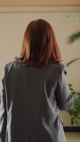businesswoman selecting drink from vending machine in office, casual office break, woman in suit, using modern vending machine, office environment, choosing beverage, break time