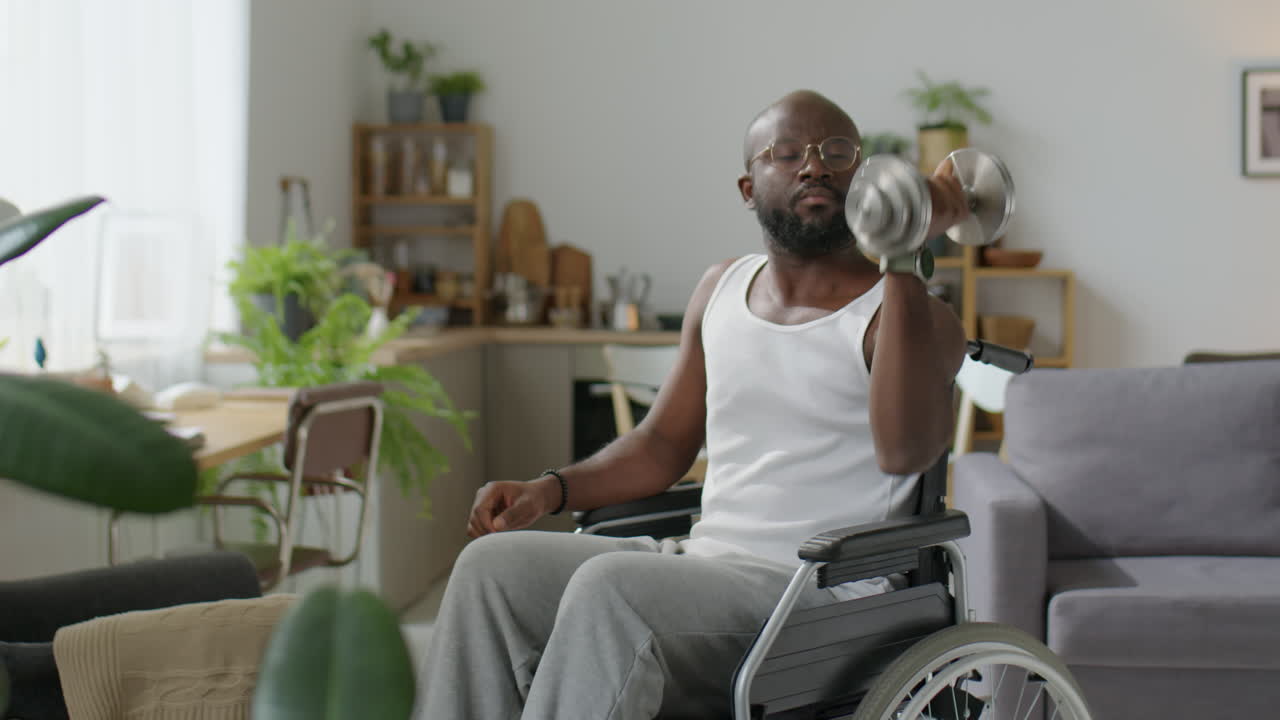 Black Man in Wheelchair Training with Dumbbell at Home