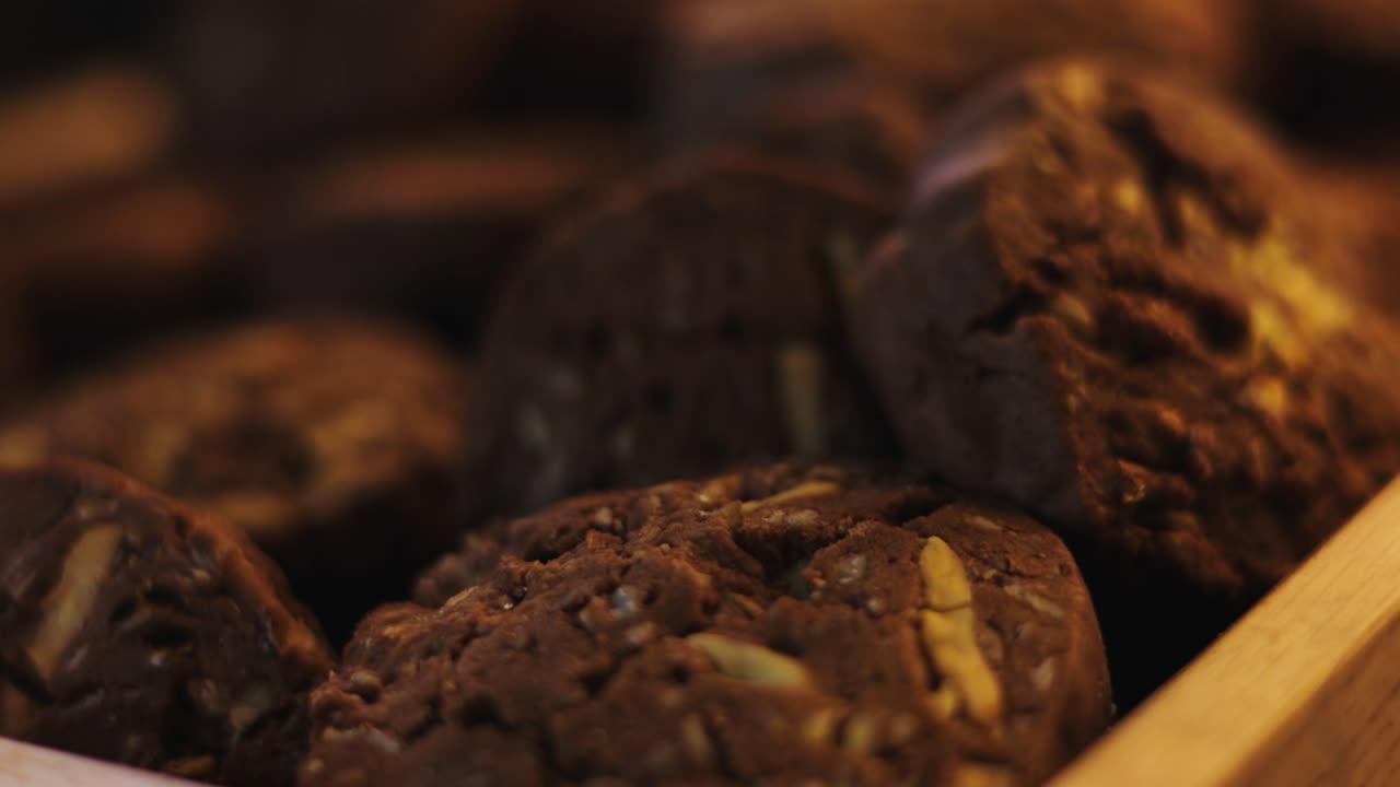 Biscotti con gocce di cioccolato e frutta secca su tavolo di legno, primo piano macro