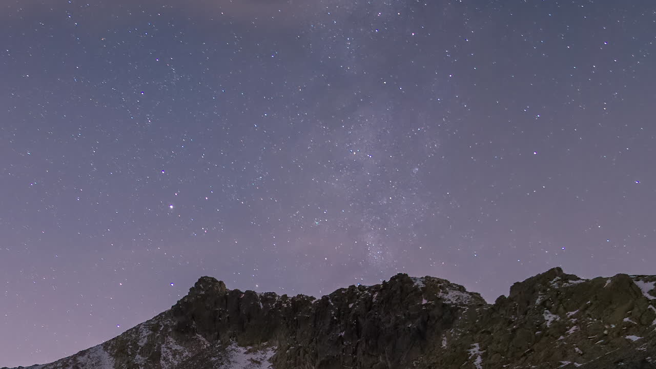 Milky way setting behind mountain peaks in Guadarrama National Park, Madrid, Spain