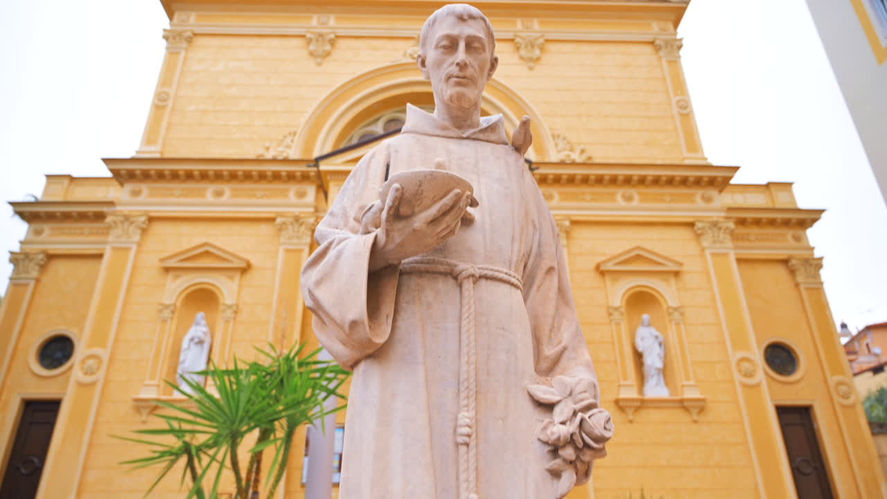 Piazza con statua di un sacerdote e una chiesa sullo sfondo a Sanremo, Italia