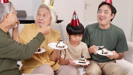 a family enjoys a birthday celebration, sharing cake and laughter in a warm, well-lit room