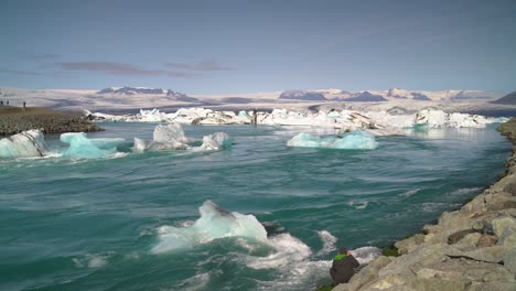 large piece of iceberg floating downstream on torrential river