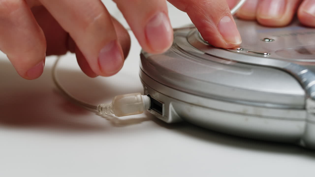Using headphone for old music portable compact player close-up. Listen to music with vintage player.
