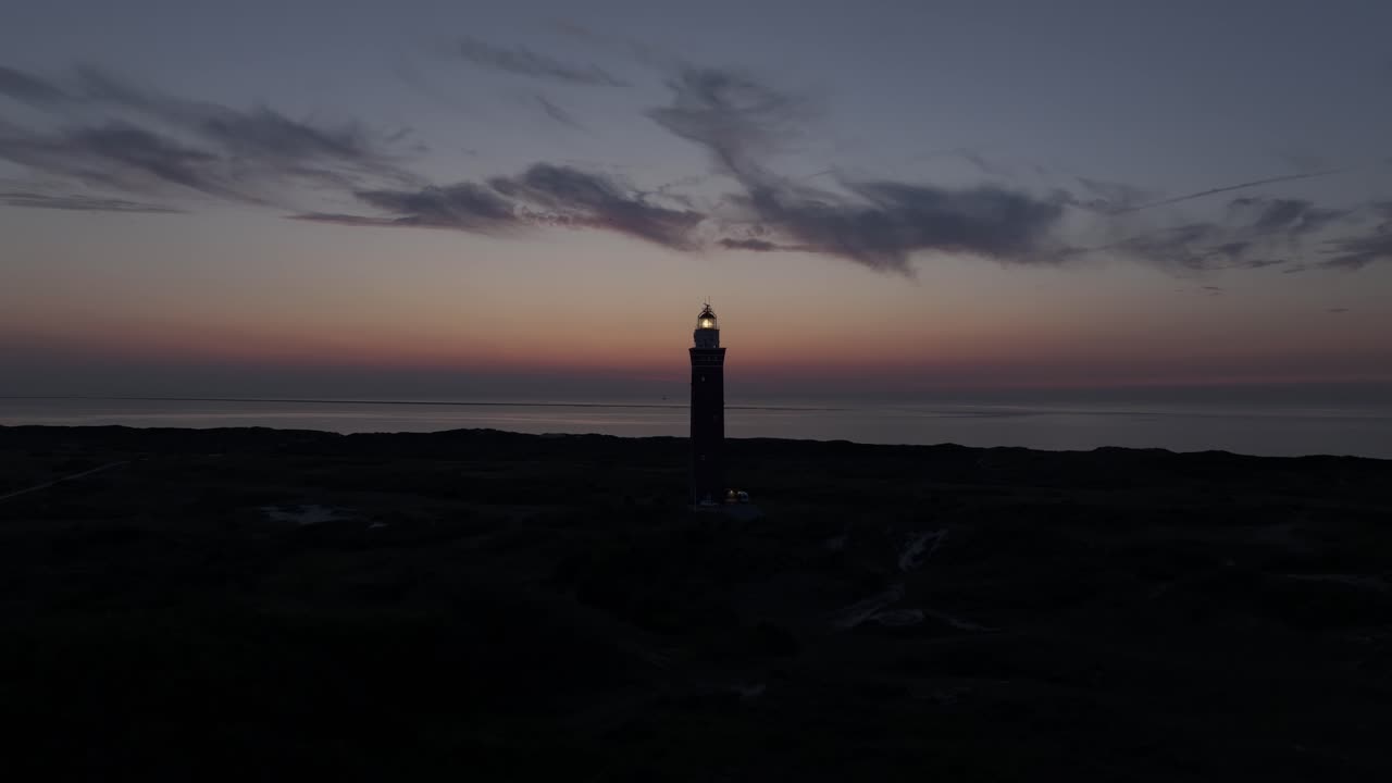 Vista aerea del faro di Westhoofd al tramonto splendido che illumina la spiaggia, le dune e la costa del Mare del Nord