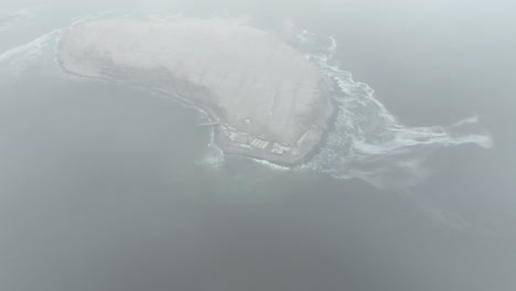 Absteigende-Luftdrohne-Schoss-über-Die-Wolken-Und-Enthüllte-Eine-Unbewohnte-Insel-Isla-San-Pedro-Im-Pazifischen-Ozean-Im-Golf-Von-Kalifornien-Mit-Blick-Auf-Die-Küste-Mit-Hohen-Wellen-Im-Meer