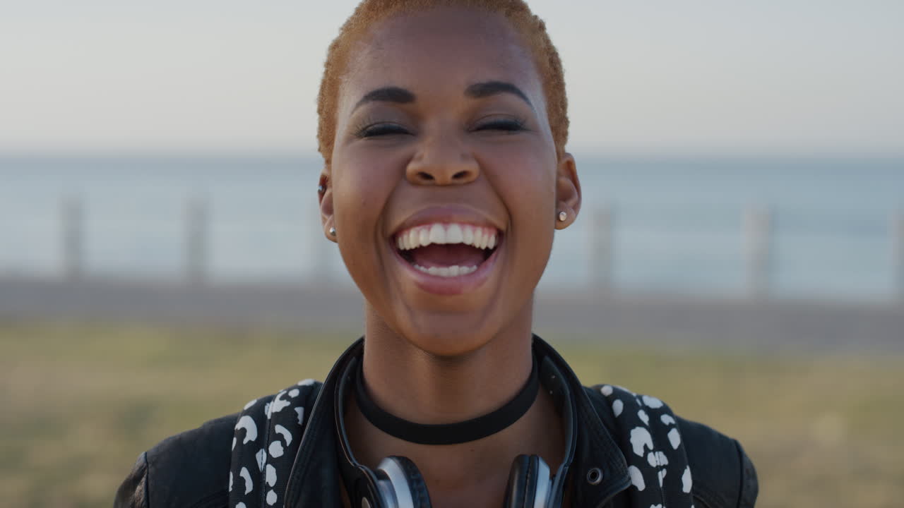 portrait stylish young african american woman laughing enjoying independent lifestyle trendy black female student looking happy on beach seaside background