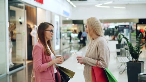 two women shopping and talking in a mall