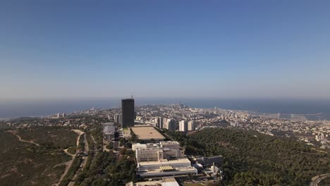 tranquil skyline of haifa city with a tall building on a hill and a harbor with the sea in the background, israel