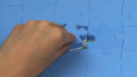 hand placing the last piece on a puzzle