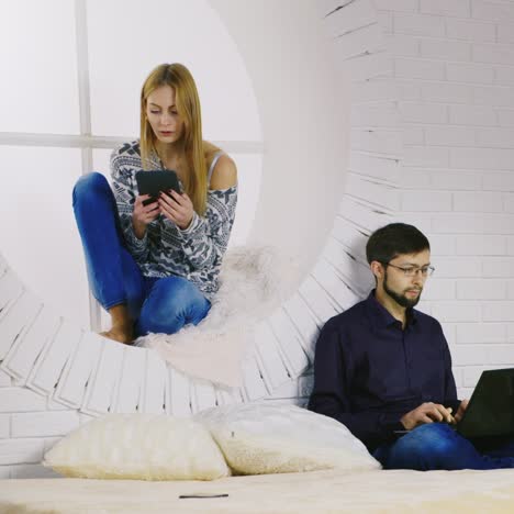 a young couple using laptop and tablet