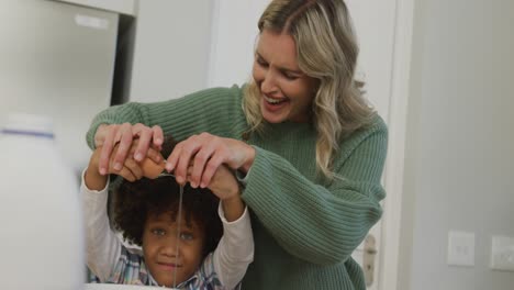 video de un hijo biracial y una madre caucásica cocinando juntos