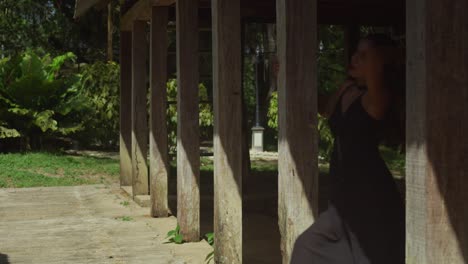 a girl in a black dress relishes the calmness of the river.