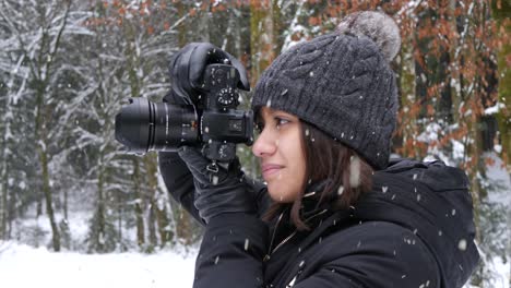 beautiful female take photos of snowfall in forestry area, close up view