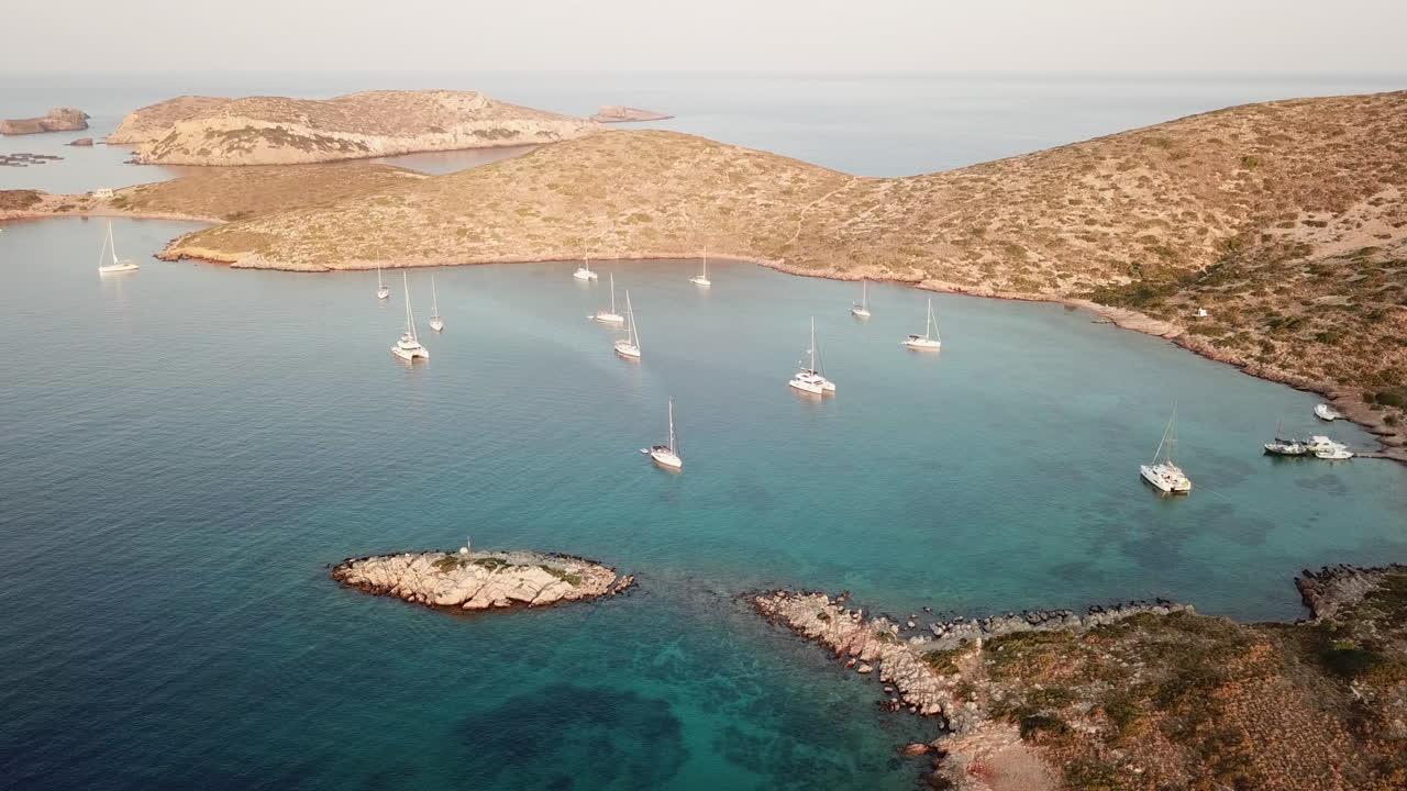 Greece,Leros Island,Archangelos bay,drone footage,smaller islands,anchored boats and fish farm, Crystal Clear waters and couple of birds fly by. Footage moves slowly from right to left and shows full.