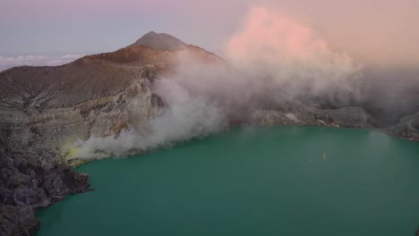 espectacular vista aérea de un creador en el volcán kawah ijen con lago de azufre turquesa y turistas