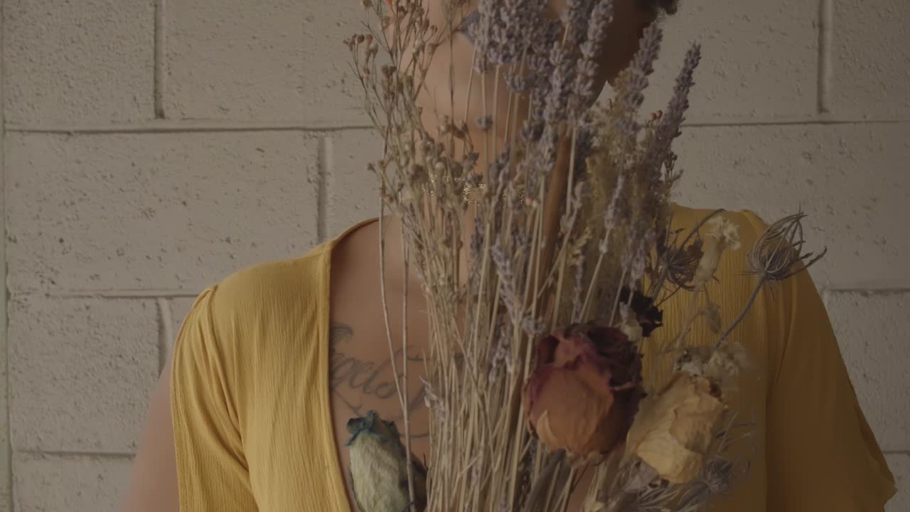 그녀의 얼굴 앞에서 말린 꽃 팜파스 꽃다발을 들고 화려한 반지와 여성 손