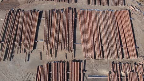 Top-down-Aerial-Above-A-Stack-Of-Lumber-Wooden-Logs-Stacked-Lumberyard