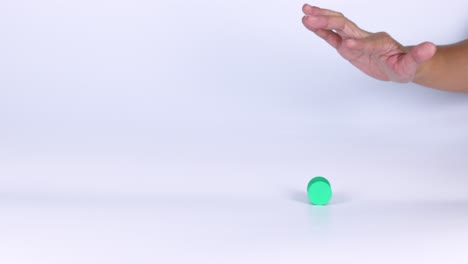 una mano manipula un pequeño objeto verde