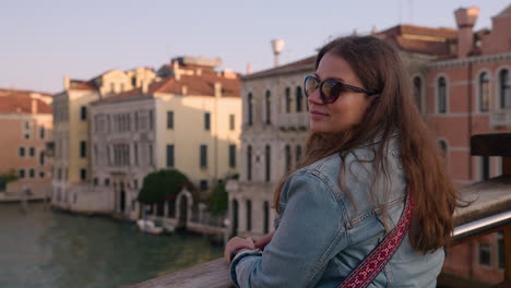 female tourist sightseeing over ponte dell'accademia in venice, italy