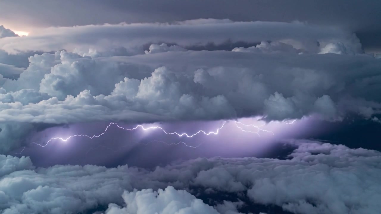 Lungo canale di fulmine lampeggiante che si muove attraverso nuvole stratificate dopo un lampo viola, rilasciando carica