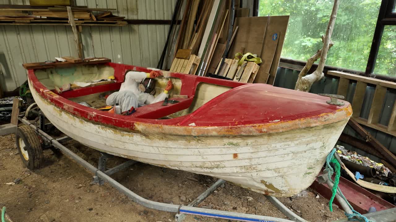 fiberglass repairing lakeboat in workshop Wide shot