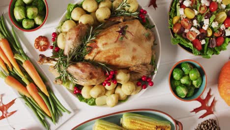 video de bandeja con pavo asado, platos diversos y decoración de otoño en superficie blanca