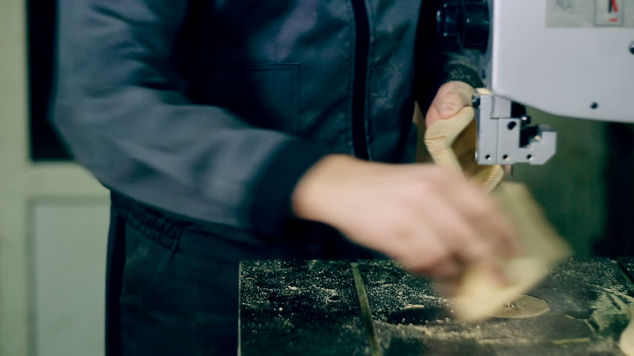 Man Uses An Electric Saw To Cut Wooden Planks. Carpenter is sawing a wooden plank with jig saw machine in carpentry workshop