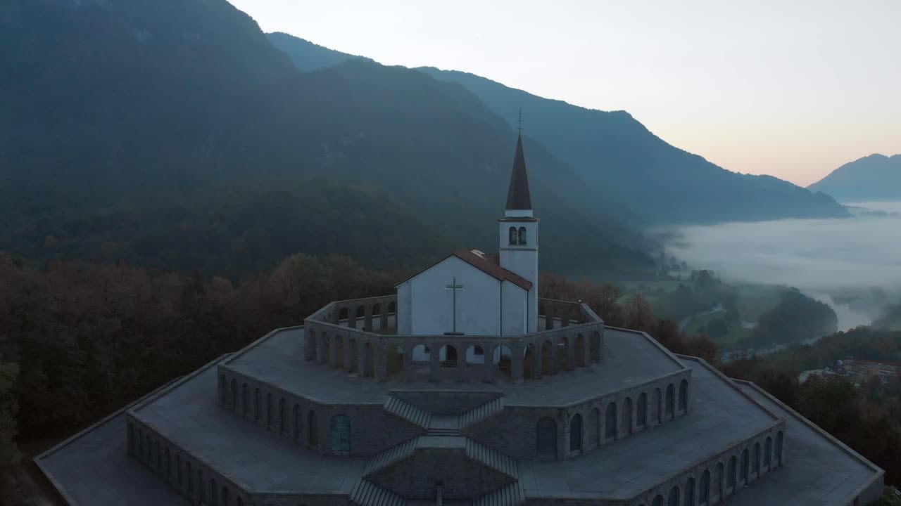 circular aerial view of italian charnel house with church above Kobarid, spring morning