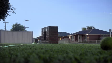 low-view-of-a-sprinkler-wateingr-a-front-lawn-in-a-suburban-street