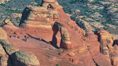 arches national park with tourists exploring its scenic landscape - aerial drone shot