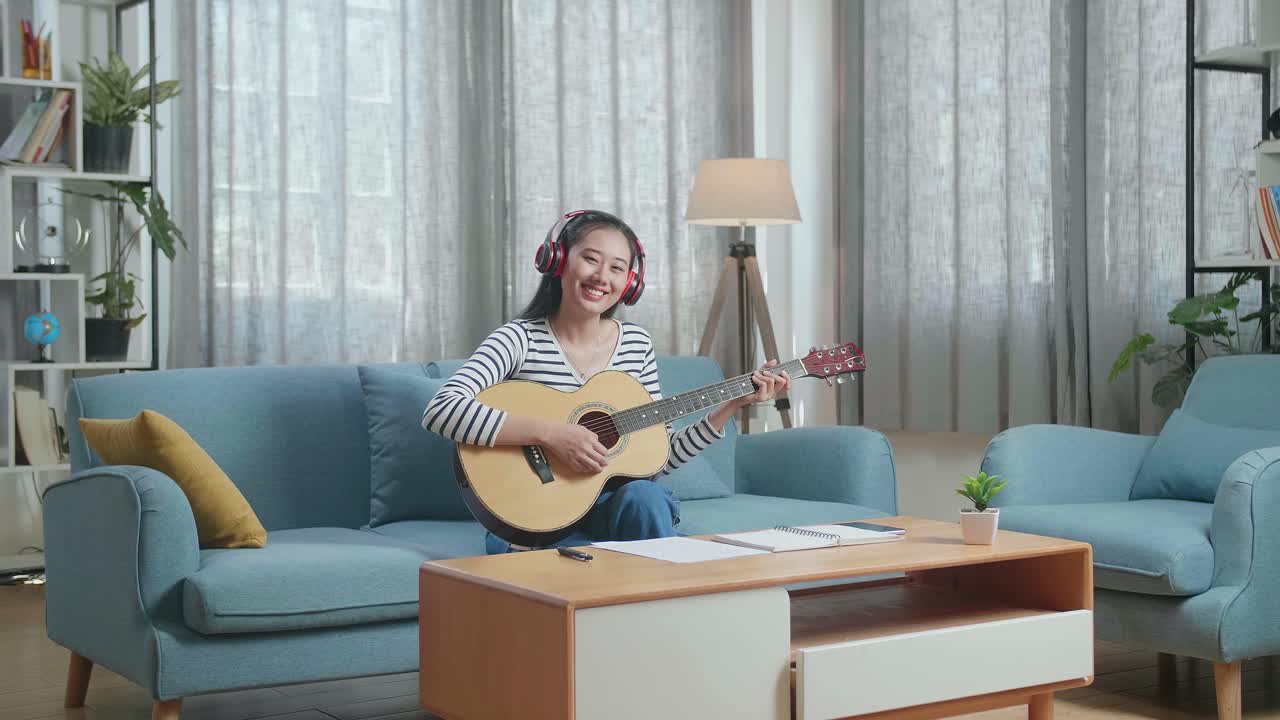 집에서 어쿠스틱 기타를 연주하는 여자