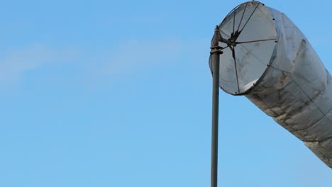 windsock swaying against a clear blue sky