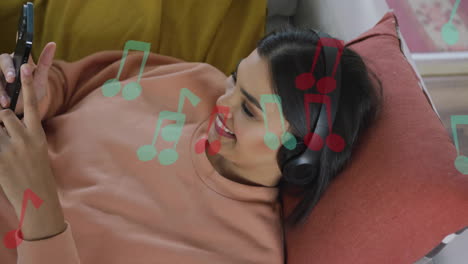 animation of music notes over biracial woman using headphones at home