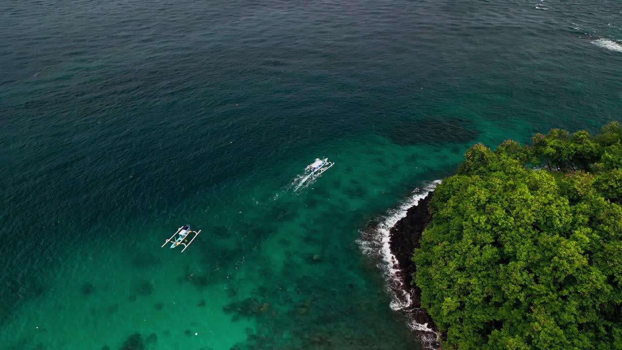 Drone footage captures the calm turquoise waters of Blue Lagoon Beach in Karangasem. Coral reefs, lush forest, and small traditional fishing boats, the peaceful shore of this tropical getaway