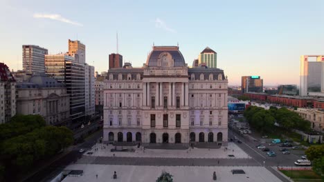 vista aérea dolly frente al centro cultural kirchner al atardecer en el fondo, centro de buenos aires